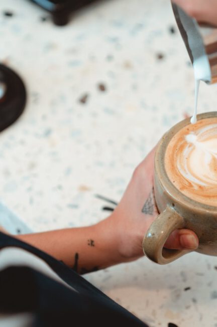 photo of barista pouring milk on latte